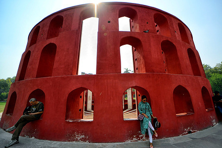 Indian visitor seen inside a structure at Jantar Mantar in New Delhi. The Jantar Mantar is a collection of architectural astronomical instruments, built in 1724 by Maharaja Sawai Jai Singh. The observatory consists of thirteen major geometric devices for measuring time, predicting eclipses, tracking stars' location as the earth orbits around the sun, ascertaining the declinations of planets, and determining the celestial altitudes and related ephemerides.