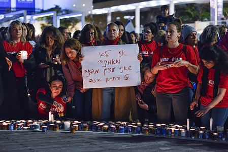 Female protesters in red, light candles while another holds a placard reading: 'I don't believe I still need to protest for this shit' in memory of Darya Leital, the fifth domestic violence homicide victim in Israel this year. Over 200,000 people protested in Tel Aviv against Netanyahu’s far-right government and its controversial legal reform.