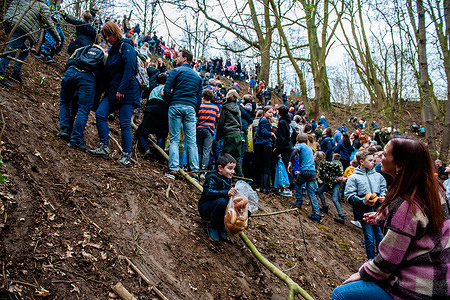 A little boy is seen going down the hill with a bag full of buns. Every year halfway through the fasting period, a procession is held in Sittard city going to the 100-meter-high hill called 'Kollenberg'. At Kollenberg, around 15,000 crescent-shaped bread buns are thrown out for the children.