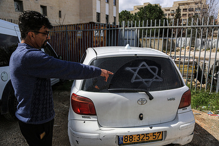 A Palestinian man inspects his car allegedly sprayed by Jewish settlers in the east Jerusalem neighborhood of Sheikh Jarrah. Extremist Jewish vandals on Tuesday morning punctured the tires of vehicles parked outside homes of their Palestinian owners, witnesses said.