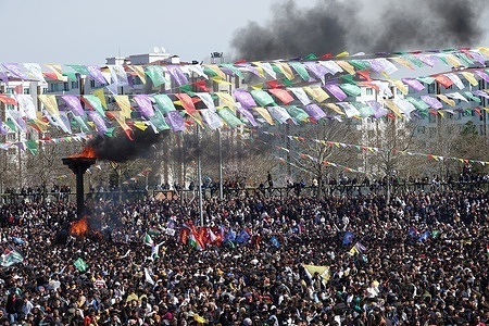 A nawroz fire is lit on a large torch with wood amid a crowd in Diyarbakır. Nawroz and fire are imposed on a Kurdish legend in history. According to legend, a blacksmith named Kawa fights against the cruel king and kills him. Kawa lights a fire to announce publicly that he has killed the king. A traditional Kurdish celebration marking the arrival of spring, Newroz is celebrated every year on March 21 in Turkey. Every year, a final celebration is held in Diyarbakir, the largest city of the Kurdish region. The event is typically attended by thousands of Kurds wearing colorful national outfits.