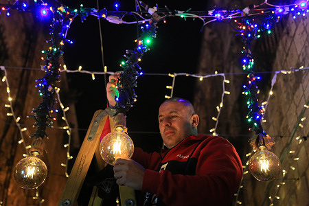 A man hangs festive light decorations ahead of the Muslim holy month of Ramadan at Bab Hutta (Gate of Remission) in the Muslim Quarter of the old city of Jerusalem.