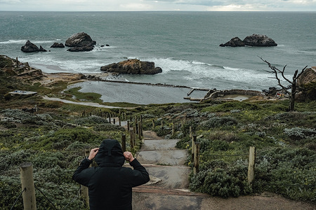 A man strolling along the restored pathways of the Sutro Baths ruins, with the Pacific Ocean stretching out behind them and seagulls soaring overhead. Sutro Baths, a historic landmark that once housed the world's largest indoor swimming pool complex, continues to captivate locals and tourists alike with its fascinating history and stunning ocean views. Built in 1896 by former San Francisco Mayor Adolph Sutro, the baths were a grand attraction that welcomed visitors from all over the world. The complex was an engineering marvel, featuring six saltwater pools, a massive glass dome, and seating for thousands of spectators.
Over the years, the baths underwent several changes in ownership and purpose. In the 1960s, the complex fell into disrepair and was eventually destroyed by a fire in 1966. Today, all that remains of the once-mighty complex are the concrete ruins that stand as a testament to the site's rich history. Despite its tragic end, Sutro Baths continues to draw crowds to its picturesque location on the western edge of San Francisco. Visitors can explore the ruins and take in the breathtaking views of the Pacific Ocean and the surrounding cliffs. The area is also popular for hiking, picnicking, and birdwatching.