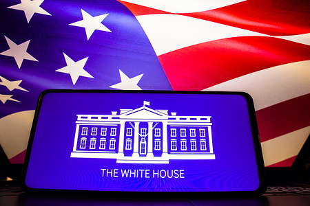 In this photo illustration, the White House logo seen displayed on a smartphone screen, United States of America flag in the background.