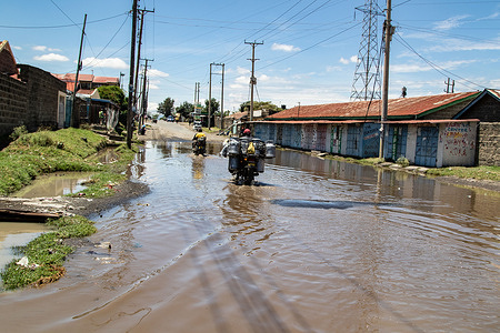 Motorcyclists navigate through a flooded road in Nakuru, following heavy rainfall that marks the return of the rainy season after a prolonged dry spell.