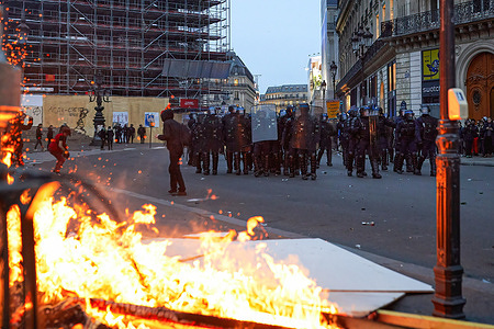 A group of police officers observes the fire set by the demonstrators. Violence clashes occurred between protesters and police on the 9th day of action against the French government's proposed reform that would see the retirement age rise from 62 to 64. Trade Unions claimed 800,000 protesters took to the streets in Paris. Police sources estimated the number at around 120,000. The government of Emanuel Macron has announced it will use a constitutional clause to push through the measure without a vote in Parliament.
