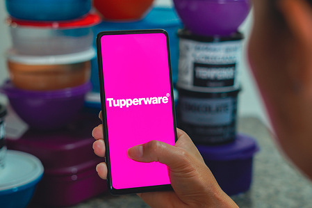 In this photo illustration a smartphone displaying the Tupperware logo.
