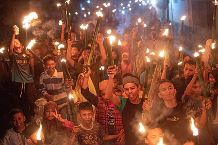 Participants hold torches during the Torch relay to welcome Eid al-Fitr. The parade is an annual event and is carried out by the people of Ranomeeto, South Konawe, Southeast Sulawesi.