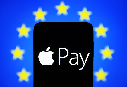 In this photo illustration, an Apple Pay logo is seen on a smartphone and European Union (EU) flag on a pc screen.