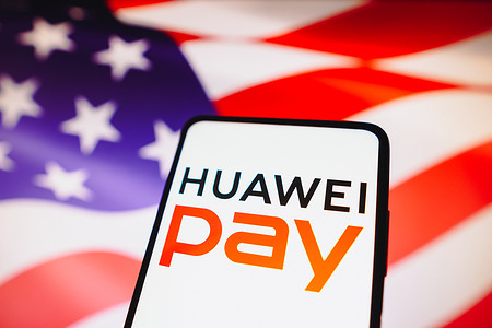In this photo illustration, the Huawei Pay logo is displayed on a smartphone screen and in the background, the flag of the United States of America.
