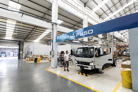An employee seen working in the assembly line for the Fuso Canter at Fuso truck factory in Tramagal. The lightweight truck factory produces 57 vehicles a day. Since 1980, when serial production of the Fuso Canter began, around 250,000 units of this model have been produced. The production of the electric model of Fuso started in the first half of 2023.