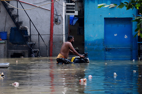 A man wades through the floodwaters with a motorcycle despite slight decrease of the water level of river Yamuna. The Yamuna river broke a 45 years record and reached its highest level of 208.65 meters.