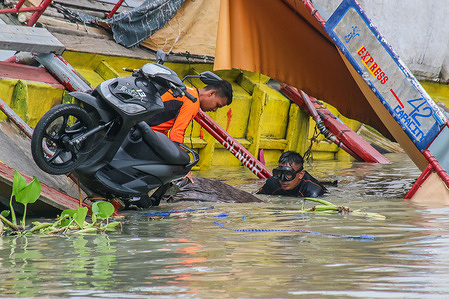 Rescue workers are seen in Laguna Lake in the midst of the search operation. A motorized boat named Princess Aya was capsized during the mid-day of July 27, 2023 due to a strong wind of Typhoon Doksuri and Southwest Monsoon in Binangonan. The passenger boat carried an estimate of 70 passengers, 40 of them survived and 26 passengers were pronounced dead. According to the investigation, and the Philippine Coast Guard said that the motorized boat can only take a maximum of 42 passengers, the captain and crew members. The retrieval operation for unknown missing numbers are still ongoing