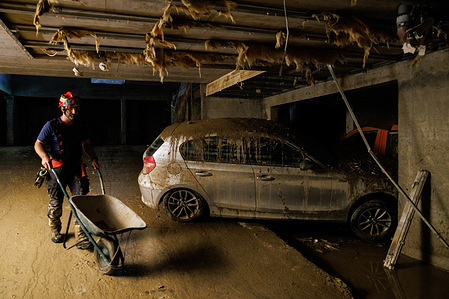 A fireman walks past a destroyed car in a garage that was flooded to the ceiling during country-wide flooding in Moste near Komenda. Clean-up and rescue efforts are still underway after torrential rain and major flooding on August 5 in Slovenia. The damage caused by the flooding is enormous.