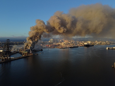 (EDITOR’S NOTE: Image taken with a drone)
Smoke seen in the sky from a fire scene at the port of Oakland. On August 9th at 5:30 p.m., a fire breaks out at the port of Oakland, prompting an immediate response from the Oakland and Alameda Fire department. Firefighters and a fire boat are dispatched to the scene to combat the blaze. The fire generates a substantial amount of smoke, filling the air and casting a dense haze over the sky in the vicinity of the port. As a result of the fire's impact on air quality, an air quality advisory is issued for the East Bay of the San Francisco Bay Area.