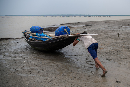 A fisherman is seen going fishing at the river Shibsha. Not too long ago, Kalabogi, a coastal village in Bangladesh, was full of cultivable land until the rising sea levels began to swallow the area up. Frequent cyclones and floods have hit the village since the late 1990s. As most of the village land was submerged, the people of Kalabogi built new homes on bamboo poles 4 to 5 feet above the ground.