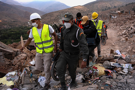 Men carry a motorbike in the destroyed village of Imi N'Tala. A village turned into a cemetery, and 90 percent of the population of Imi N'Tala were killed by the severe earthquake on Friday 8 September.