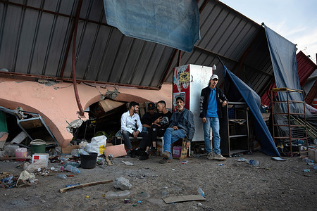 A group of men sit in front of damaged petrol station shop, completely flattened by the earthquake in the Moroccan Atlas town of Idni. The earthquake in Morocco on Friday 8 September was the worst in the country's history, leaving more than 2,000 people dead.