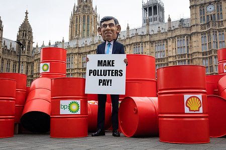 An Oxfam protester dressed as Rishi Sunak is seen outside Parliament. Oxfam's "Make Polluters Pay" campaign is calling on large oil and gas companies such as BP and Shell, to pay more taxes to help raise funds to aid communities devastated by climate change.