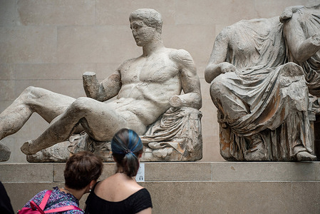 Visitors observe the Elgin Marbles, a collection of Greek sculptures from the Parthenon in Athens on display in the British Museum, London.