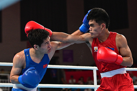 Mark Ashley Fajardo (R) of the Philippines and Xiangyang Wang of China (L) are seen during the 19th Asian Games boxing men's 57-63.5Kg round of 16 match held at the Hangzhou Gymnasium. Wang is the winner on point 5-0.