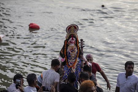 Hindu devotees carry an idol of the goddess Durga during the final day of Durga Puja festival.