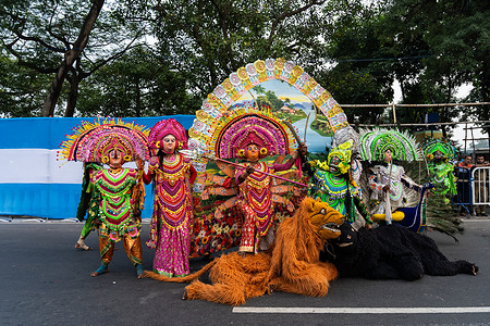 A group of Chhau dancers (semi classical Indian dance with martial and folk traditions) dressed as goddess Durga (ten-handed Hindu goddess on lion) on the road during the Durga puja carnival. Durga Puja is a Hindu festival and one of the biggest Bengali festivals, included in UNESCO's Intangible Cultural Heritage of Humanity. Durga Puja represents the collective worship of the Hindu Goddess Durga. The West Bengal Government organized a carnival with various puja pandals in Kolkata, India. Clubs participate in this carnival by arranging tableaus, dancing, and singing.
