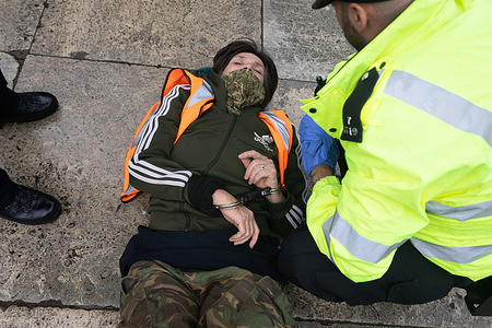 An activist from the group Just Stop Oil is arrested after staging a march outside Parliament Square in London. Just Stop Oil, a British environmental activists group, staged a march around Parliament Square demanding an end to new oil and gas licenses. After 10 minutes, police officers blocked the path and started to arrest the activists under the UK's new anti-protest laws.