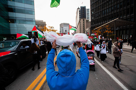 A protester holds a towel with fake blood symbolizing the children killed by Israeli air strikes during a "Cease Fire on Gaza" rally. A massive gathering of over a thousand protesters from in and around Detroit attended the rally in solidarity with Palestine. The residents of Detroit and nearby communities have been organizing frequent rallies due to Israel's escalating bombardments and attacks on Gaza, which began after an attack by Palestinian militant group Hamas on Israel on October 7, 2023. Detroit is home to the largest Arab population in the United States, including many Palestinians.