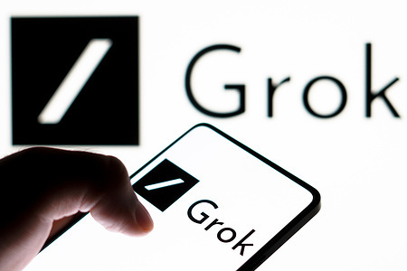 In this photo illustration, the Grok logo is displayed on a smartphone screen. Grok is an artificial intelligence chatbot associated with the social network X, created by Elon Musk.