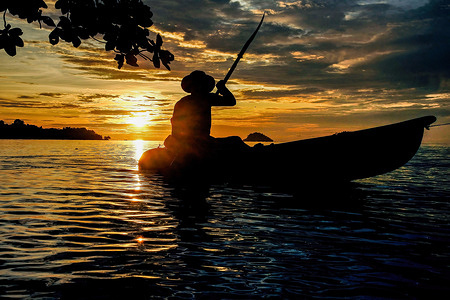 General view of a man paddling a kayak at sunset. Koh Chang is a popular tourist resort island situated about 350 km south east of the capital, Bangkok. Koh Chang is a popular tourist resort island situated about 350 km south east of the capital, Bangkok.