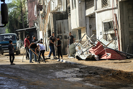 Palestinians walk through a destroyed street after an Israeli military raid in Tulakrem refugee camp in the West Bank.
