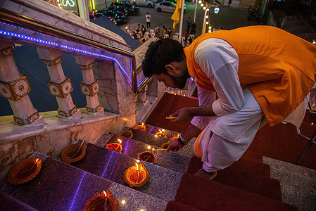 Hindu devotee lights the oil lamps during the celebration to mark Diwali festival at Wat Vishnu in Bangkok. Diwali is a celebration of the day Lord Ram returned to his kingdom in Ayodhya with his wife Sita and his brother Lakshmana after defeating the demon Ravana in Lanka and serving 14 years of exile as per Hindu mythology.