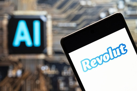 In this photo illustration, the Revolut logo seen displayed on a smartphone with an Artificial intelligence (AI) chip and symbol in the background.