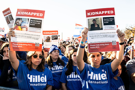 Protesters hold placards expressing their opinion during the March For Israel rally on the National Mall in Washington, DC.