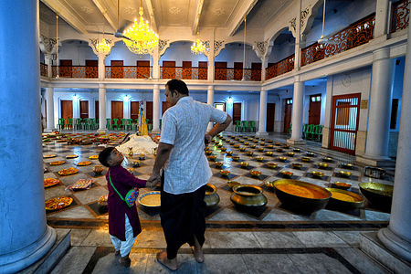 A little child with his uncle prepare for 'Annakut' or 'Govardhan Puja' festival at Naba Brindaban temple in Kolkata. Annakut or Govardhan Puja is a Hindu festival in which devotees prepare and offer a large variety of vegetarian food to Lord Krishna as a sign of gratitude for saving them from floods as per Hindu Mythology.