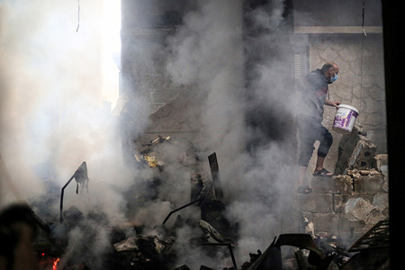 A Palestinian tries to put out the fire in his house after Israeli planes bombed his house this morning, in the city of Khan Yunis, south of the Gaza Strip. Thousands of civilians, both Palestinians and Israelis, have died since October 7, 2023, after Palestinian Hamas militants based in the Gaza Strip entered southern Israel in an unprecedented attack triggering a war declared by Israel on Hamas with retaliatory bombings on Gaza.