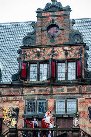 St. Nicholas is seen talking to the children from one of the oldest buildings of the city. The first Saturday after November 11th, the red-and-white-clad Sinterklaas (St. Nicholas) arrives with great fanfare in several Dutch cities. In Nijmegen, the white-bearded legend makes his entrance into the city by sailing down the river and following a route through the city accompanied by his helpers, the Pieten (Peters) who were giving traditional candies to children and adults.