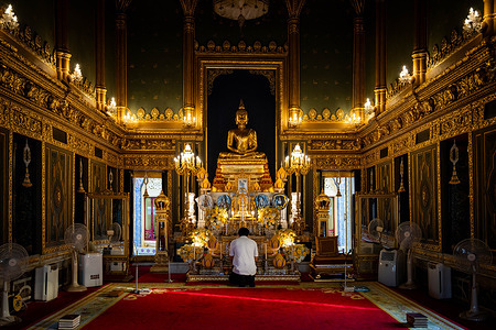 Someone prays at a royal temple within the Grand Palace in Bangkok. The Thai Government pushed for growth in the international tourism market by enacting visa-free entry programs to the Kingdom for international tourists from Russia, China, and India.