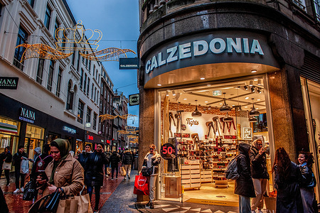 People carrying shopping bags wait outside the Calzedonia clothes store. In Amsterdam, shops are ready with Black Friday deals, and the store windows are decorated with sales banners to attract people during Black Friday. Younger people, in particular, are waiting for the discount day after America’s Thanksgiving to buy things.