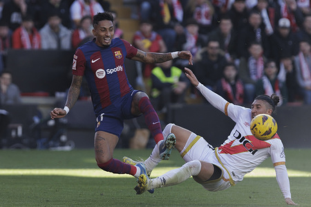 Alfonso Espino (R) of Rayo Vallecano and Raphael Dias Belloli, known as Raphinha (L) of Barcelona seen in action during the LaLiga EA Sports 2023/24 match between Rayo Vallecano and Barcelona at Vallecas Stadium. (Final scores; Rayo vallecano 1-1 FC Barcelona).