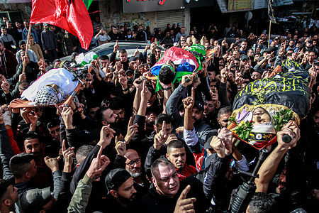 (EDITORS NOTE: Image depicts death)
Mourners carry the bodies of three of the five Palestinians killed in the occupied West Bank city of Jenin in an overnight Israeli incursion, during their funeral. Five people were killed by Israeli army fire in Jenin, the Palestinian health ministry said, during an incursion by a large number of armored vehicles into the city, which was recently the scene of the deadliest Israeli raid in the West Bank in almost 20 years.