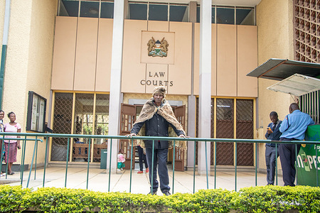 A member of the Ogiek Community stands in front of the Nakuru High Court after the discussion of their petition challenging the Kenyan Government's efforts to evict them from the Mau Forest. The Ogiek, an indigenous forest-dwelling community, filed a lawsuit against the government last month, contesting their eviction from Mau Forest, a location they have called home for centuries.