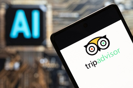 In this photo illustration, the American travel agency and restaurant website company TripAdvisor (Trip Advisor, NASDAQ: TRIP) logo seen displayed on a smartphone with an Artificial intelligence (AI) chip and symbol in the background.