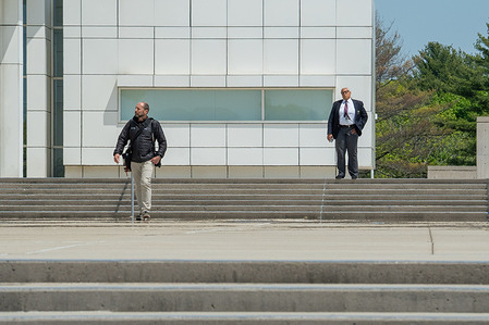 A Walden Security Court Security Officer watches a photographer outside of the main court entrance. George Santos, U.S. House representative for New York's 3rd congressional district, appears in Federal court in Central Islip, Long Island after pleading not guilty to 13 federal charges over accusations that he misled donors and misrepresented his finances to the public and government agencies.
