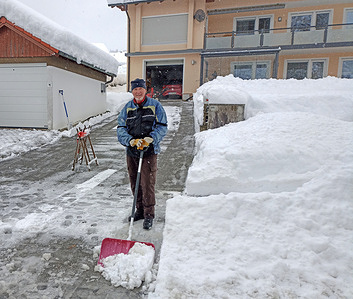 An elderly man clears snow from the area in front of his house. On the night of December 2, 2023, heavy snowfall hit Bavaria; more than 15 to 25 cm of snow fell in one day. The same snowfall is expected in the coming days. Due to the large amount of snow that fell, there was power outages throughout the day. Bavarian authorities is warning of the dangers of snowfall on roads.
