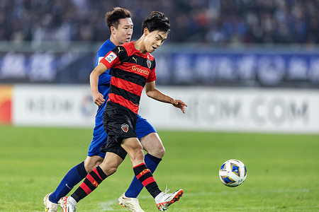 Cho Jae-hun #26 (R) of Pohang Steelers seen in action during the AFC Champions league football match between Wuhan Three Towns FC of China and Pohang Steelers of South Korea at Wuhan Sports Center Stadium. Final scores; Wuhan Three Towns FC of China 1-1 Pohang Steelers of South Korea.