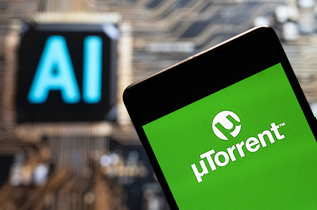 In this photo illustration, the software Utorrent logo seen displayed on a smartphone with an Artificial intelligence (AI) chip and symbol in the background.