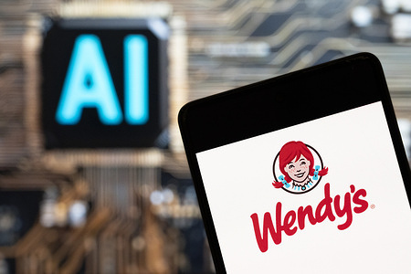 In this photo illustration, the American fast food restaurant chain Wendy's (NASDAQ: WEN) logo seen displayed on a smartphone with an Artificial intelligence (AI) chip and symbol in the background.