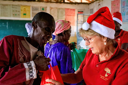 Volunteers at Family Care Mission distribute Christmas food packages to residents in Kibera Slum.